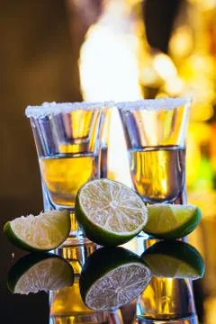 Stack of tequila with salt close up on blurred background Stock Photos