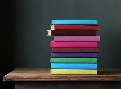 Stack of textbooks in the colored cover on the table. Stock Photos