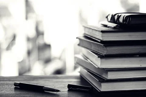 A stack of textbooks on a table Stock Photos