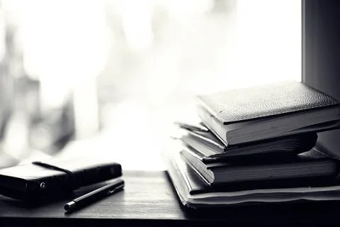 A stack of textbooks on a table 스톡 사진