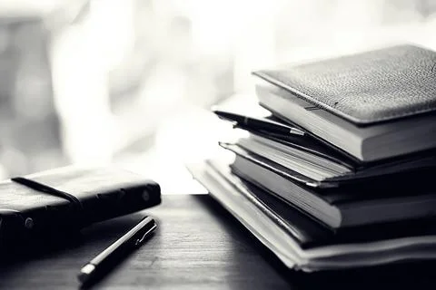 A stack of textbooks on a table Stock Photos