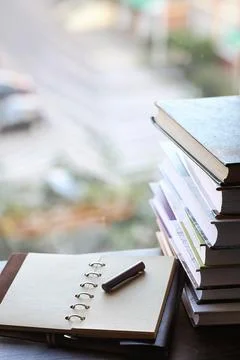 A stack of textbooks on the windowsill Stock Photos