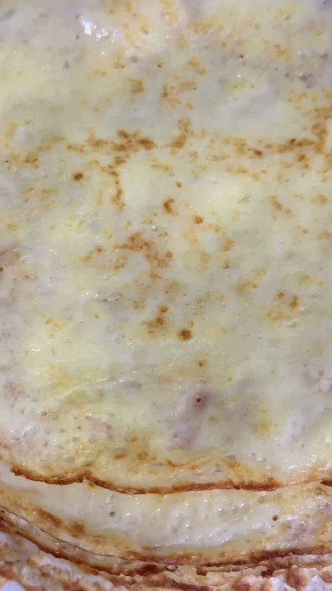 Stack of thin golden brown crepes on a plate Stock Footage 331982175