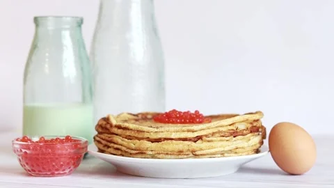 A stack of thin pancakes with caviar on a light background Stock Footage 234192933