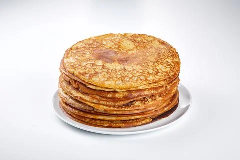 Stack of thin pancakes on a white plate and on a light background Stock Photos