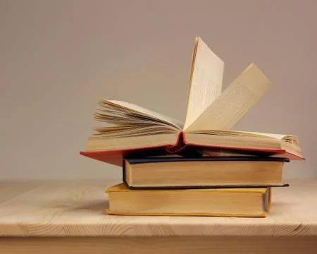 Stack of three books in the colored cover on the table. Stock Photos