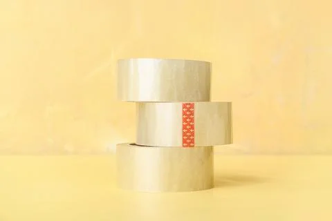Stack of three clear packing tapes with red arrows on yellow background for s Stock Photos