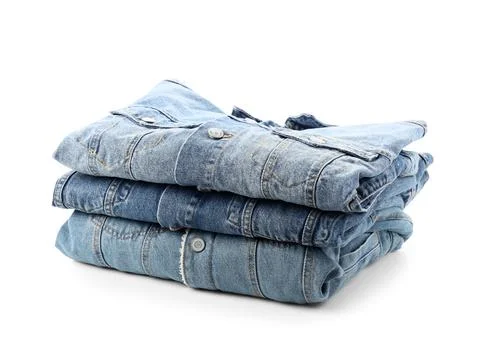 Stack of three folded blue denim jackets with metal buttons, casual fashion a Foto stock
