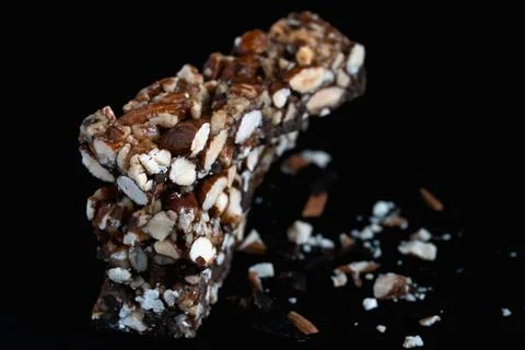 Stack of three homemade nut and chocolate granola bars on black background 写真素材