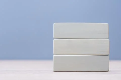 Stack of three natural wooden rectangles isolated on blue backdrop. Perfect t Stock Photos