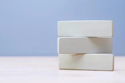 Stack of three natural wooden rectangles isolated on blue backdrop. Perfect t Stock Photos