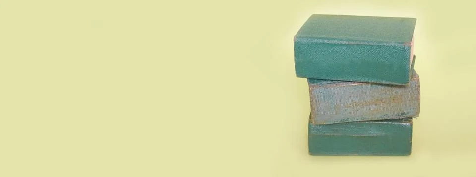 A stack of three old books lies on a plain background. Banner Foto stock