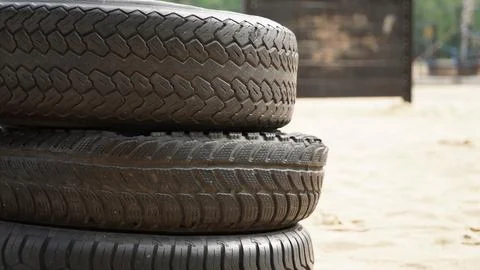 Stack of Three Old Tires on Sand Stock Photos