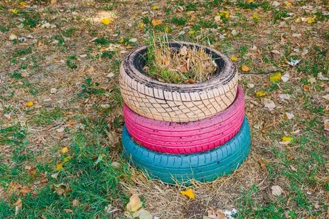 Stack of three painted tires in beige, pink and blue used as a decorative g.. Stock Photos