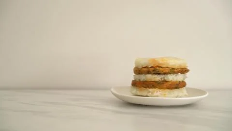 Stack of three rice cakes with vegetables on a white plate Stock Photos