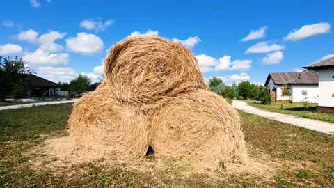 A stack of three round hay bales sits in a village yard Stock Footage 280009208