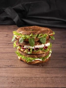 Stack of three simit sandwiches top of each other on wooden table Stock Photos