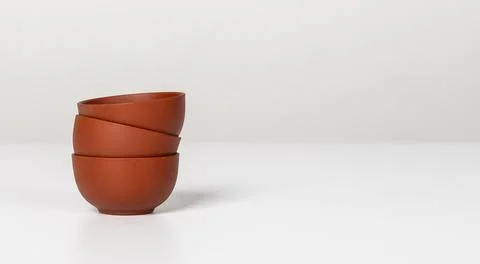 Stack of three small ceramic cups, bowls on table. Banner background with Stock Photos
