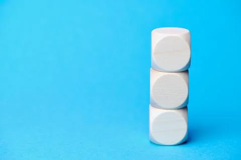 Stack of three wooden cubes against blue background Stock Photos