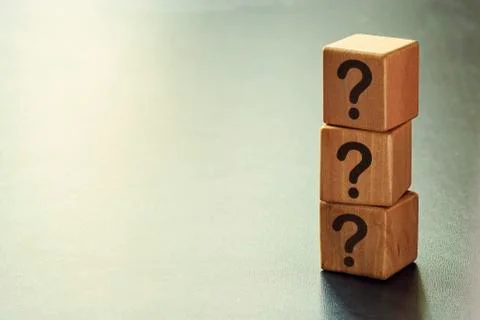 Stack of three wooden cubes with question marks Stock Photos