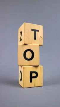Stack of three wooden letter blocks spelling top on gray background, for ra.. 写真素材