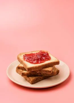 A stack of toasts with jam on a dish close-up. Plate with pieces of toasted b Foto stock