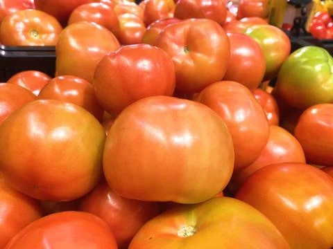 A stack of tomatoes on display at the market or grocery store 스톡 사진