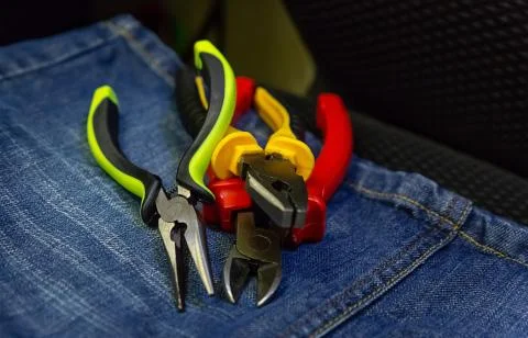 Stack of tools hand pliers colorful non-slip handles work with power tools in Stock Photos