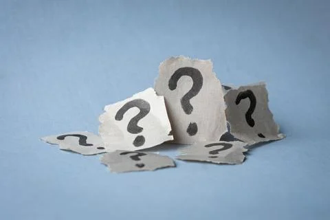 Stack of torn papers with question marks. Stock Photos