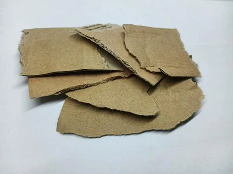 Stack of Torn Pieces of Brown Cardboard on White Background 库存照片