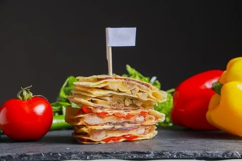 Stack of tortillas with ingredients on a dark kitchen counter Stock Photos