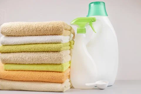 A stack of towels and laundry and bleach products on a light gray background Stock Photos