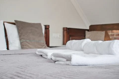 Stack of towels on the bed in hotel room Stock Photos