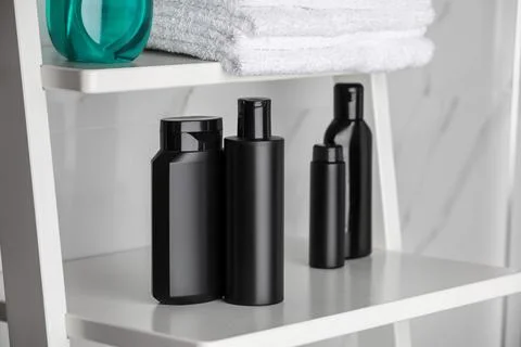 Stack of towels, shampoo and other toiletries on shelves in bathroom 스톡 사진