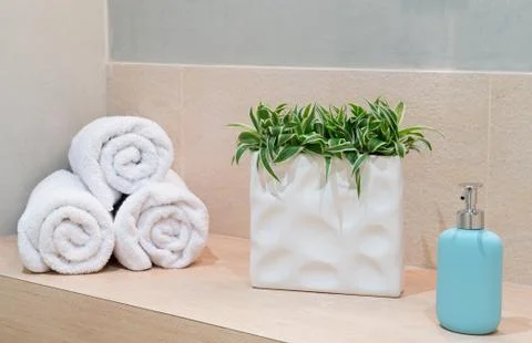 Stack of towels with a soap dispenser in a bathroom Stock Photos