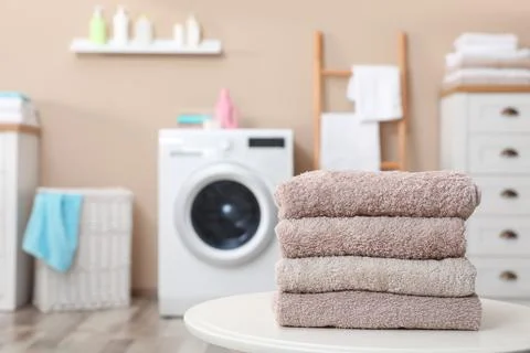 Stack of towels on table against blurred background, space for text 스톡 사진