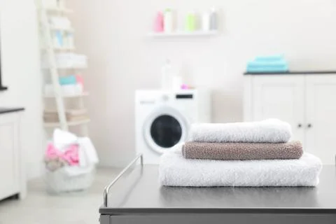 Stack of towels on table against blurred background, space for text 스톡 사진