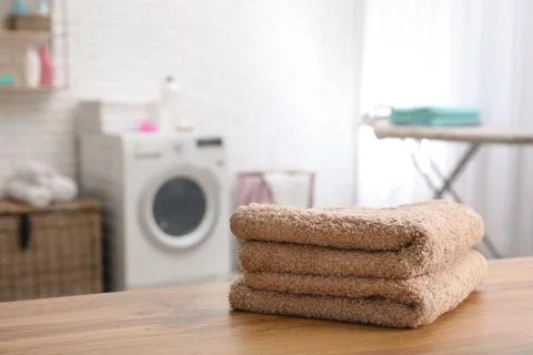 Stack of towels on table against blurred background, space for text Stockfoto's
