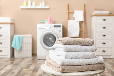 Stack of towels on table against blurred background, space for text 스톡 사진