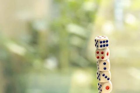 Stack tower of many small game dice isolated on a bright blurred background.. Foto stock