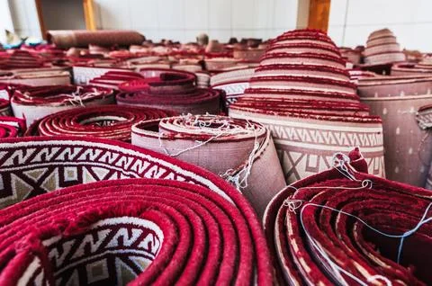 Stack of tradition oriental vintage red carpets for prayer at Minor Mosque in Stock Photos