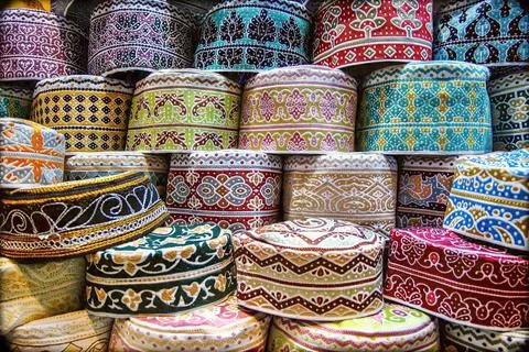 Stack of traditional embroidered caps in various colors and patterns Stock Photos