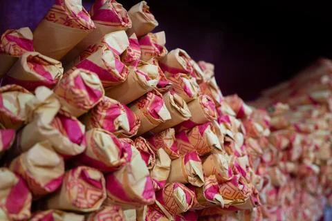 Stack of traditional incense sticks wrapped in pink and beige paper Stock Photos