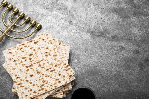 Stack of traditional matzos, menorah and red wine on grey table, flat lay. Sp Foto stock