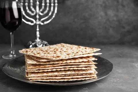 Stack of traditional matzos near red wine on grey table 写真素材