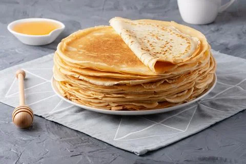 Stack of traditional russian pancakes blini on gray background. Stock Photos