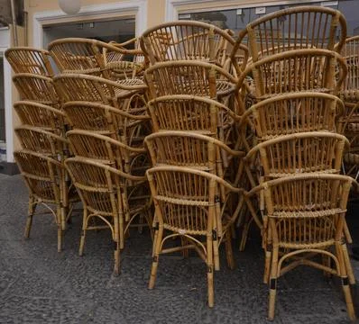 A stack of traditional wicker bistro chairs in an Italian cafe. Stock-Fotos