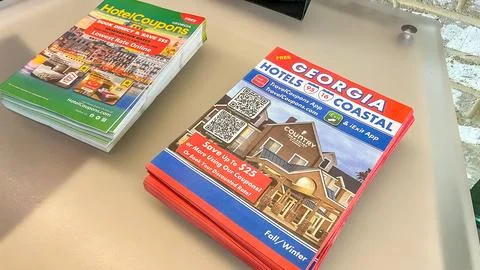 Stack of travel brochures featuring Georgia hotels and coupons displayed on a Stock Photos