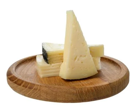 Stack of triangular pieces of cheese on round wooden board, isolated backgrou Stock Photos