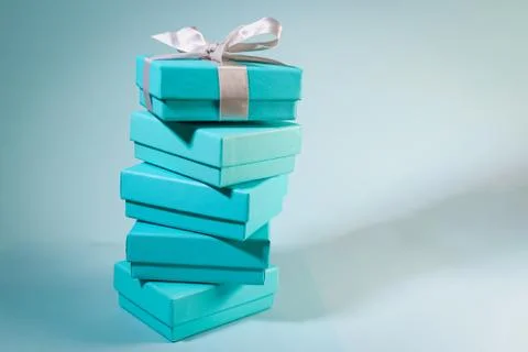 Stack of turquoise blue boxes, one tied with white silk ribbon Stock Photos